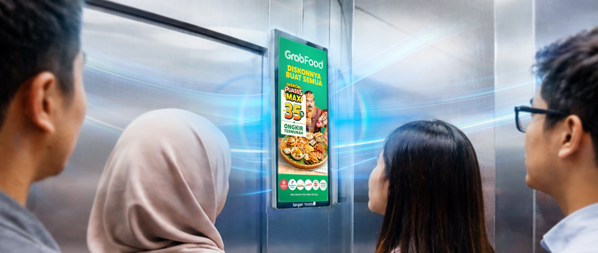 People noticing a full-screen advertisement inside an elevator